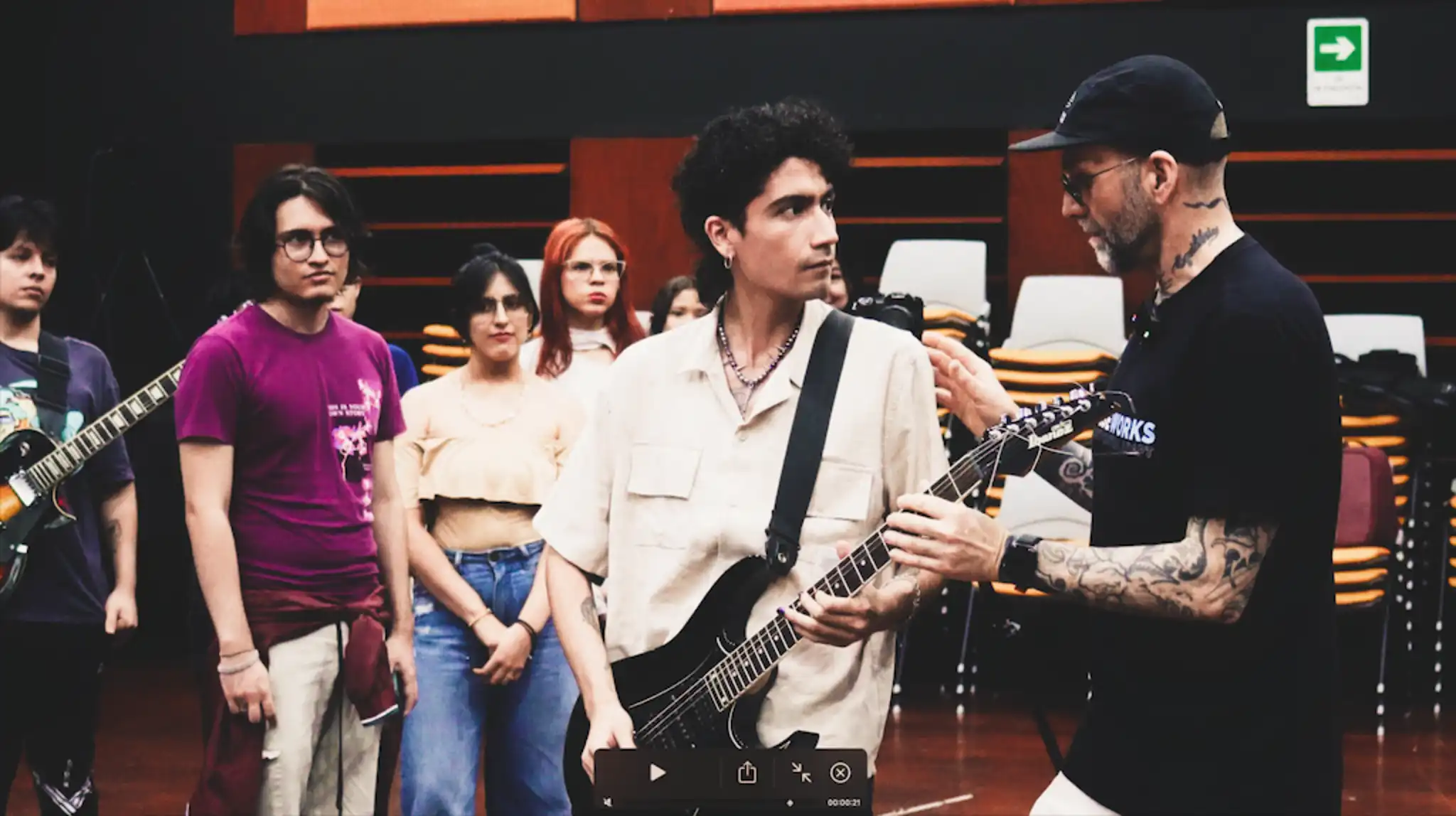 The instructor touching a music student playing guitar to highlight a sensation.