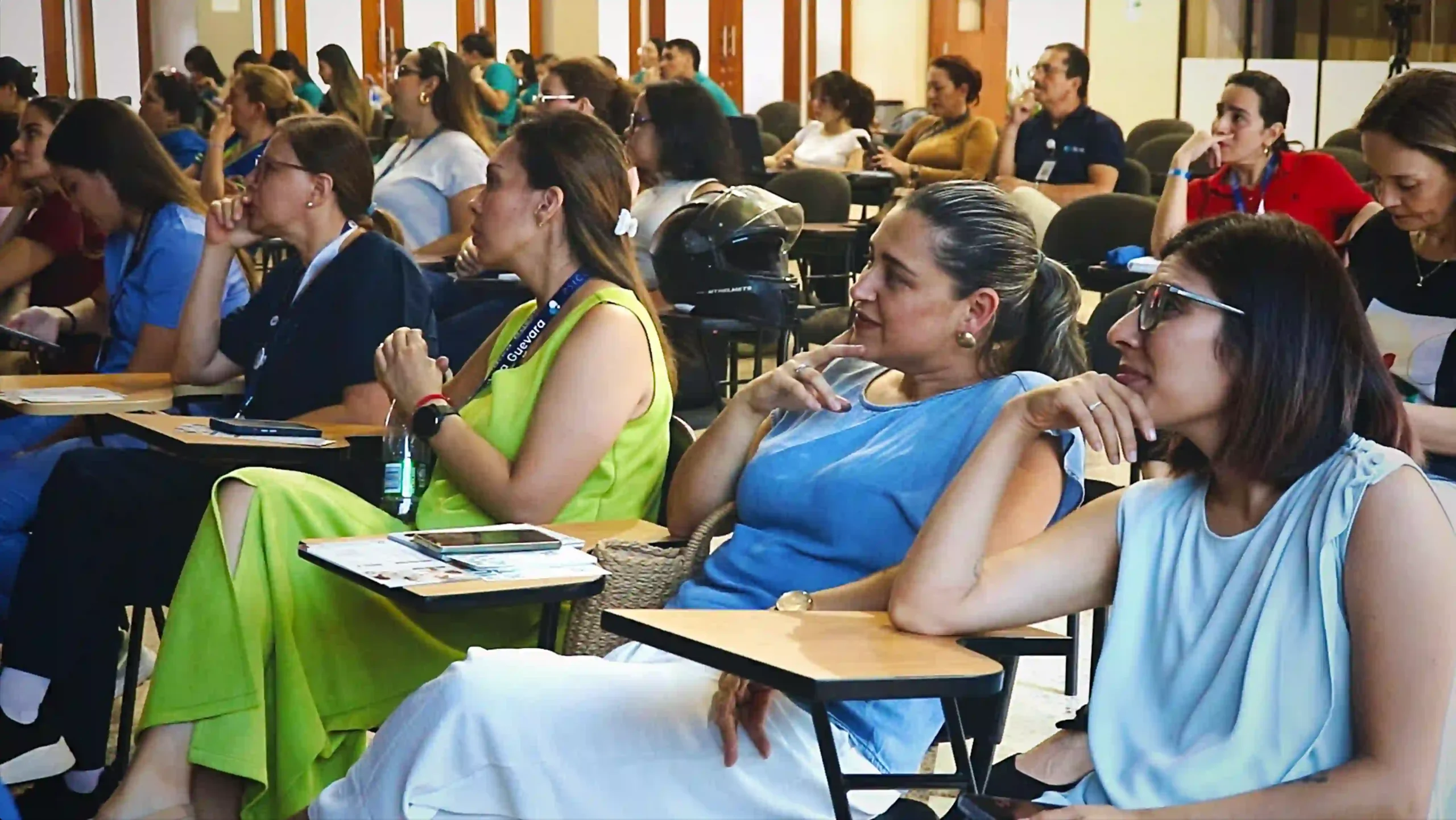 People, 90% women, intently listen to a presentation in a conference room