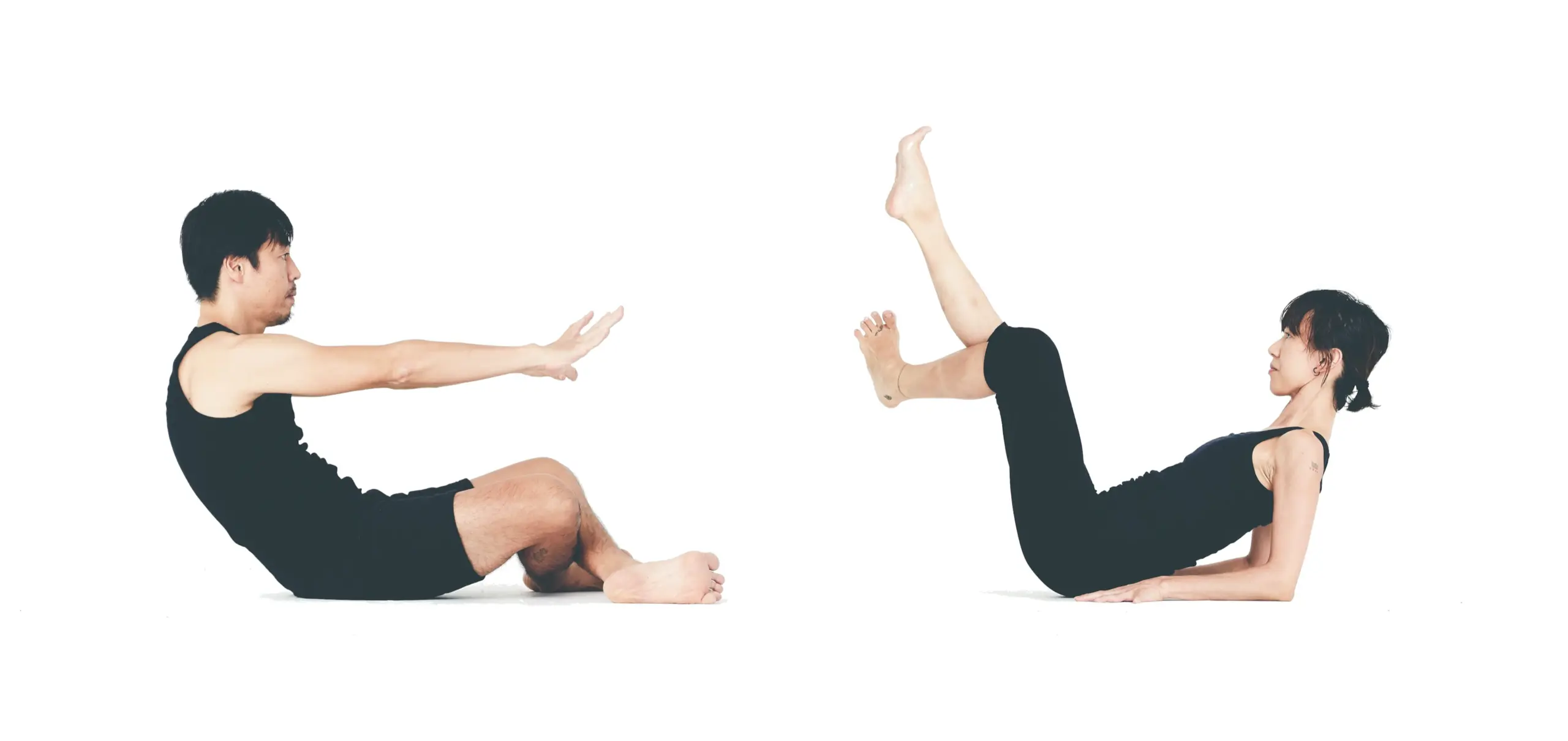Baseworks facilitators Ken Nakagawa and Shinobu Nakano seated on a studio floor facing each other, each in a different phase of a reclining transition.