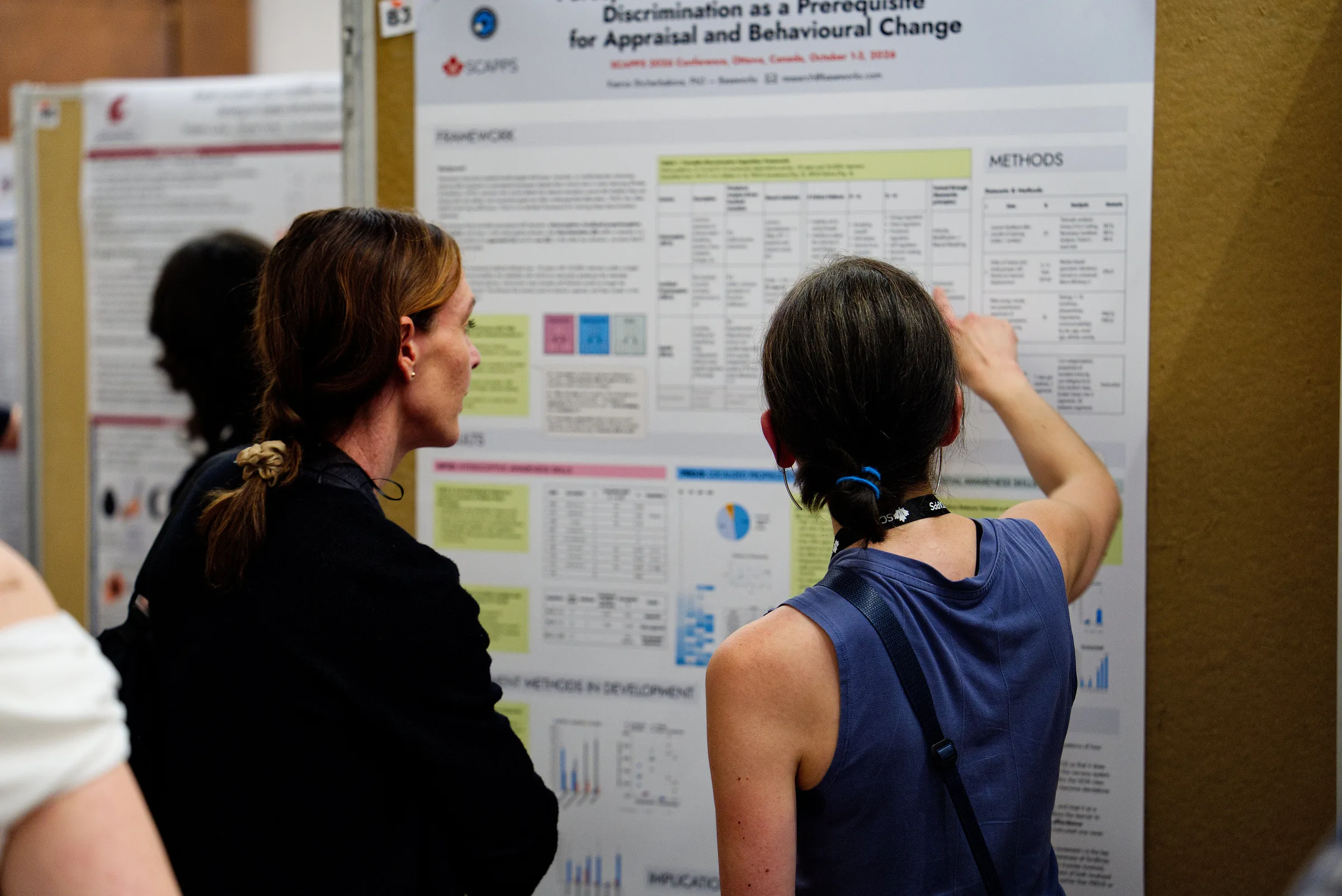 The Baseworks poster, Perceptual Skills in Movement Education: Discrimination as a Prerequisite for Appraisal and Behavioural Change, with Ksenia Asia Shcherbakova and a visitor reading it.