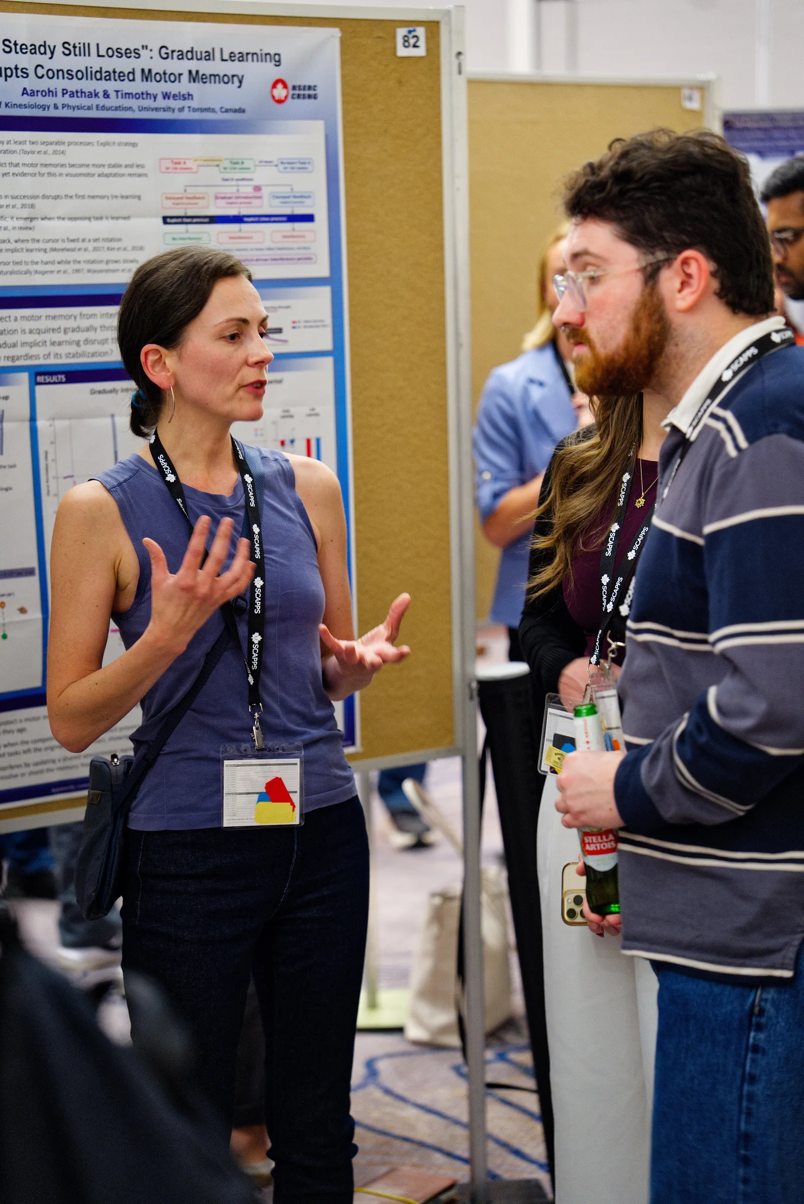 Ksenia Asia Shcherbakova explains part of her research to two visitors during the SCAPPS 2026 poster session.