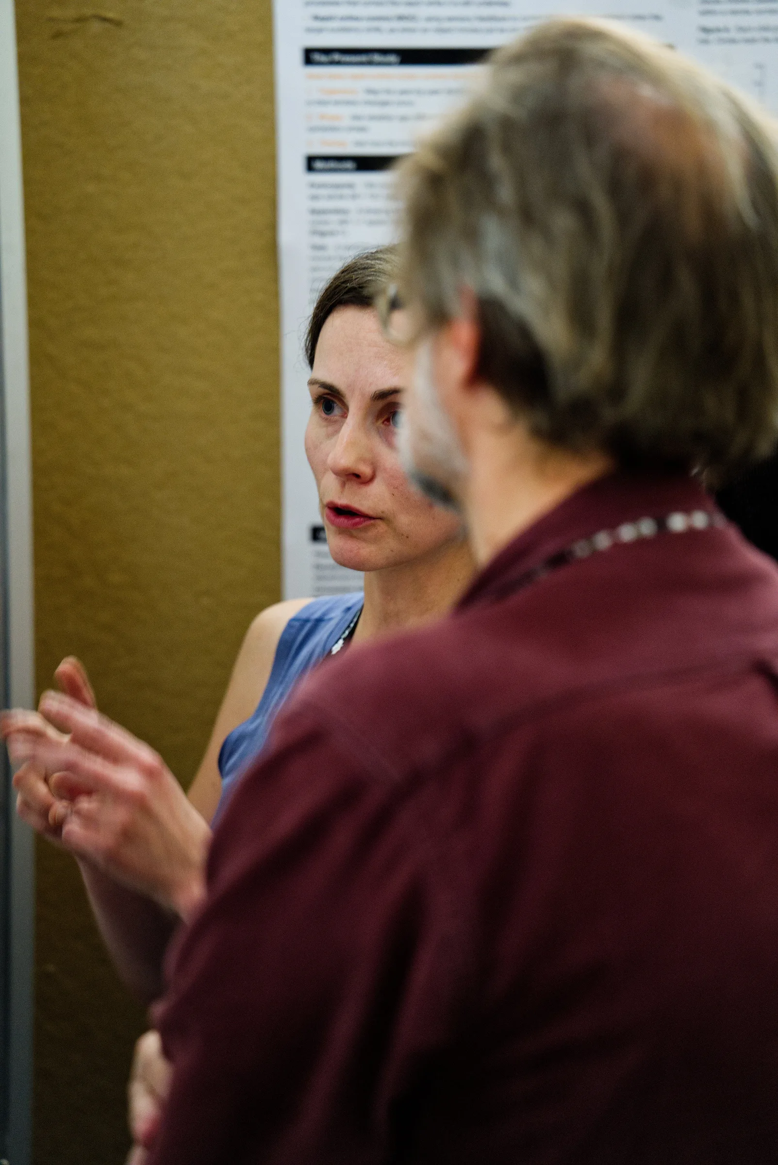 A visitor discusses the Baseworks poster with Ksenia Asia Shcherbakova at SCAPPS 2026.