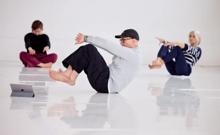 Participants holding a seated balance with arms extended during a Baseworks Winter 2026 Study Group session in Montreal